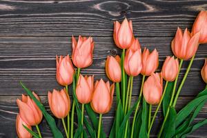 Slika divni narančasti tulipani na drvenoj podlozi