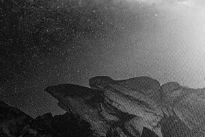 Slika zvjezdano nebo iznad stijena u crno-bijelom dizajnu