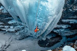 Umjetnička fotografija A woman ice climbs up a, Alex Ratson, (40 x 26.7 cm)
