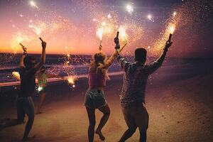 Umjetnička fotografija Friends running on a beach with fireworks, wundervisuals, (40 x 26.7 cm)