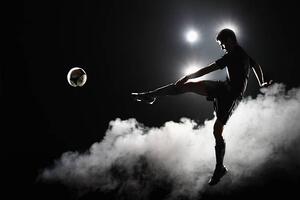 Fotografija Soccer player kicking the ball at night on stadium, Stanislaw Pytel