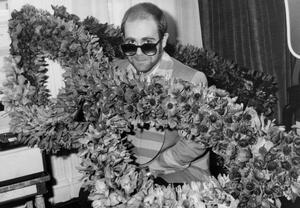 Fotografija English Singer Elton John at his Arrival in Paris : Bunch of Flowers in The Shape of Glasses He Wears, December 1St, 1976