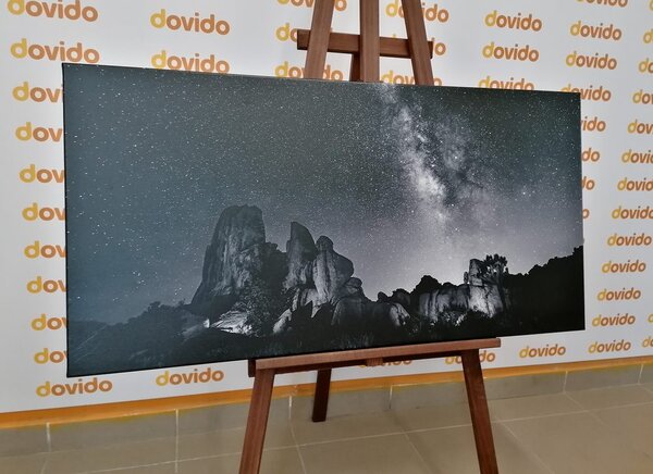 Slika zvjezdano nebo iznad stijena u crno-bijelom dizajnu