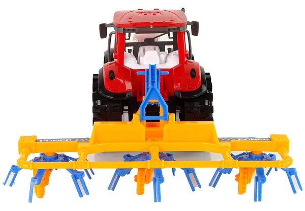 Crveni traktor s pogonom trenja grablja