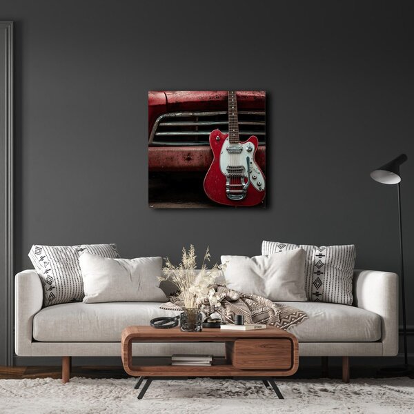 Slika crvena gitara ispred automobila